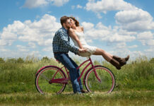 Young couple in honeymoon phase, riding a bicycle