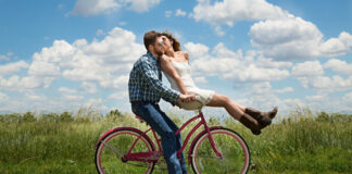 Young couple in honeymoon phase, riding a bicycle